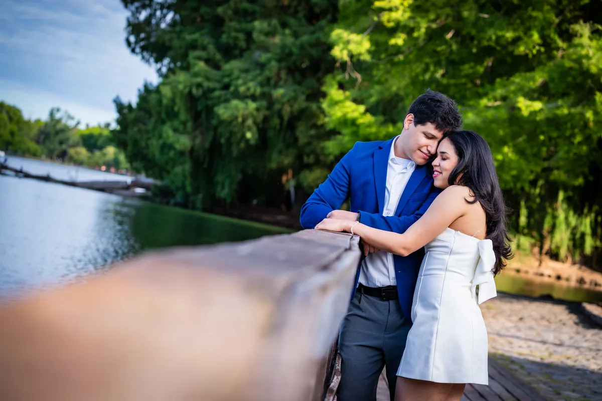 Pareja abrazada junto a un lago en un parque