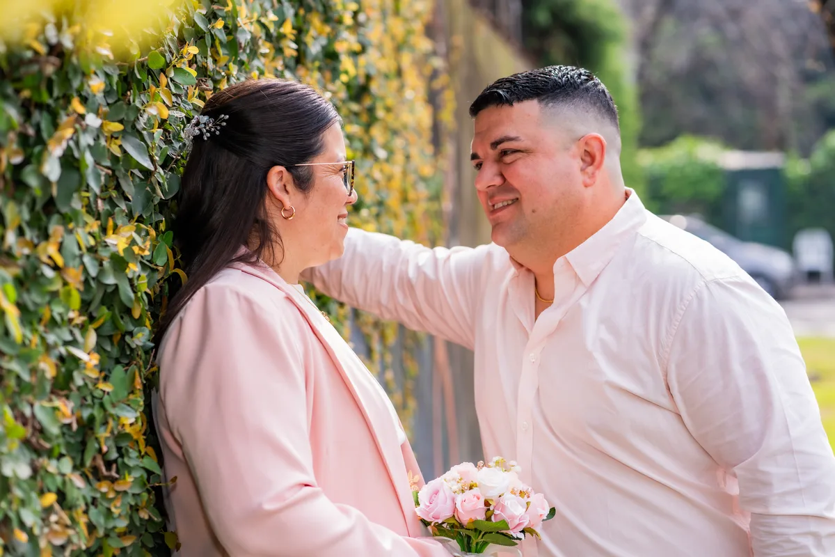 Pareja sonriendo con un ramo de flores al aire libre