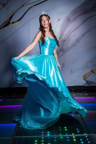 Quinceañera girando con su vestido turquesa